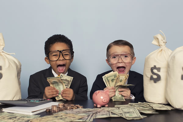 two young boys hold paper money and cheering with more money strewed on the table
