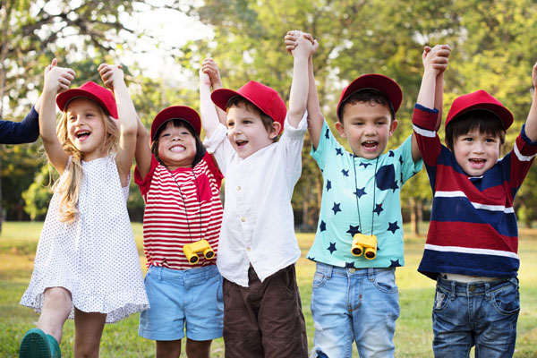 row of small children cheering and holding hands